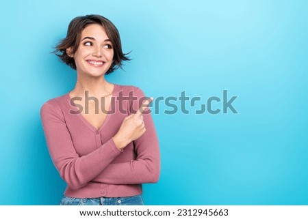Photo of shiny dreamy woman dressed pink shirt looking pointing finger empty space isolated blue color background