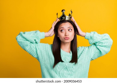Photo of shiny dreamy young woman dressed teal pullover crown arms head looking empty space isolated yellow color background