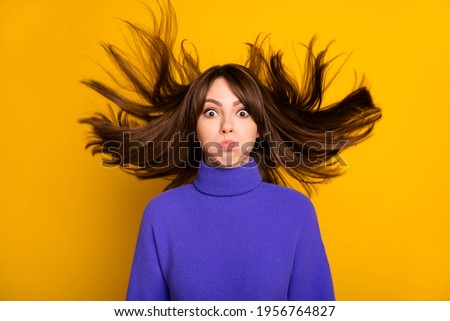 Photo of shiny funny young woman wear purple pullover air blowing hair bloated cheeks isolated yellow color background