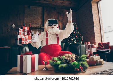 Photo of shocked addicted grey beard santa claus sit couch player play 3d simulation game use goggles wear red cap headwear in house indoors x-mas christmas decoration - Powered by Shutterstock