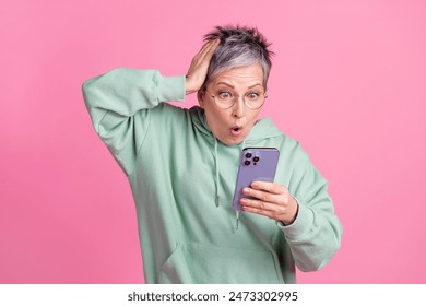 Photo of shocked cool lady dressed khaki sweatshirt reading news apple samsung iphone gadget isolated pink color background