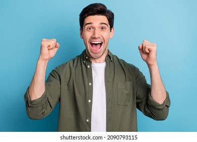 Photo of shocked ecstatic guy win luck lottery raise hands up shout yea isolated on blue color background