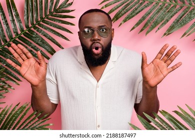 Photo of shocked funny guy dressed white shirt dark eyewear rising arms enjoying vacation isolated pink color background