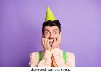 Photo of shocked terrified young man dressed yellow shirt birthday headwear biting two hands arms isolated purple color background - Shutterstock ID 1914574822