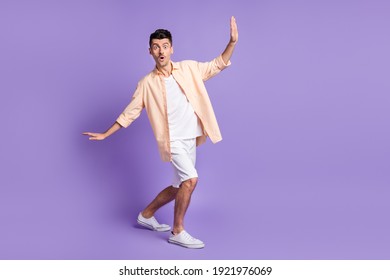 Photo of shocked young guy dance having fun look camera wear beige shirt isolated violet color background