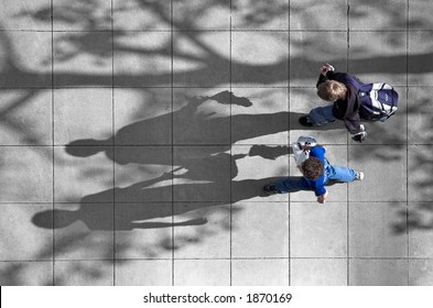 Photo Shot From Above Of Two Schoolboys Walking Along A City Street.