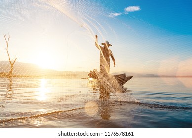 Photo shot of water spatter from fisherman while throwing fishing net on the lake. Silhouette of fisherman with fishing net in morning sunshine. - Powered by Shutterstock