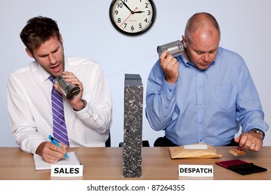 Photo showing the behind the scenes reality of the sales and despatch departments for a small business, both guys sharing the same desk and communicating via a tin can phone.
