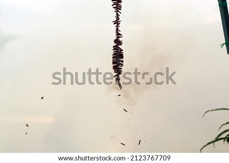 The photo showing red long firecrackers was blasting or banging for celebration. An old saying goes that the sound and heat of fireworks scares away evil spirits.