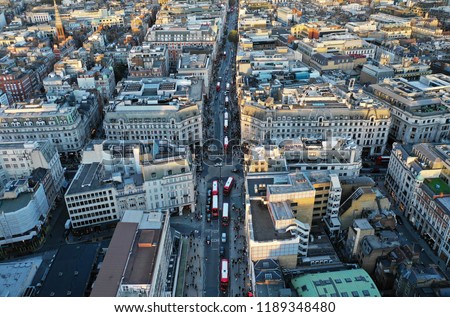 Photo shows the crowded oxford street with many busses and shoppers. Photo taken with drone during sunset hour.