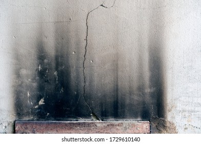 The Photo Shows A Gray Clay Wall With A Crack And Traces Of Smoke Over The Stove Door, Danger, Neglect