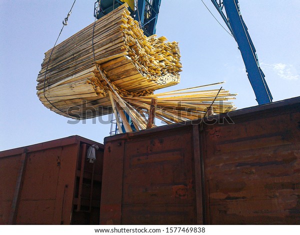The photo shows the unloading\
and storage of boards of edged sawn timber from a gondola\
car.