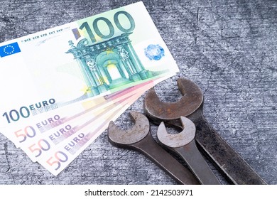 Das Foto zeigt verschiedene rostige Furnieren auf grauem Hintergrund mit Euro-Banknoten