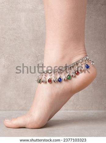 The photo shows a woman wearing Anklets on her feet.