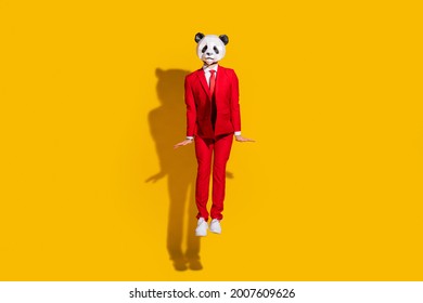 Photo Of Shy Boyfriend Panda Guy Jump Posing Wear Mask Red Suit Footwear Isolated On Yellow Color Background