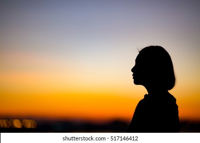 Photo Of Silhouette Adult Woman In Profile On Twilight Background.
