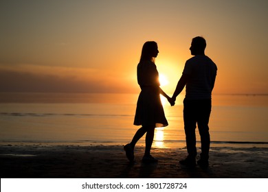 photo silhouette of a love couple. sunset, lake, romantic. portrait of a young woman and a man beach. - Powered by Shutterstock