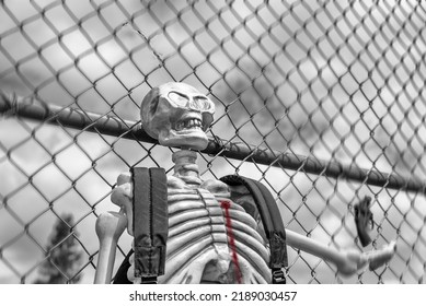 Photo Of A Skeleton Wearing A Backpack And School Fence In Black And White With Bullet Wound In Chest