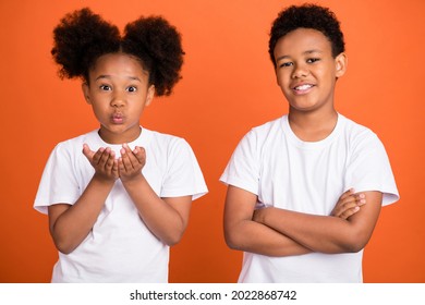 Photo Of Small Cute Girl Boy Blow Kiss Wear White T-shirt Isolated On Orange Background