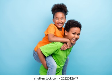 Photo of small funny brunet boy girl on him wear t-shirts isolated on blue color background
