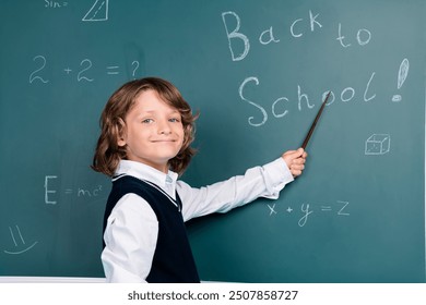 Photo of small schoolkid boy hold pointer wear uniform isolated on blackboard background - Powered by Shutterstock