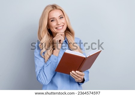 Photo of smart business lady wear stylish blue shirt touch chin thoughtful hold favorite finance book isolated on grey color background