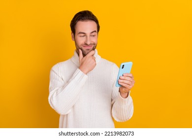 Photo Of Smart Clever Guy Hold Phone Ponder Email Answer Finger Chin Wear White Sweater Isolated Yellow Color Background