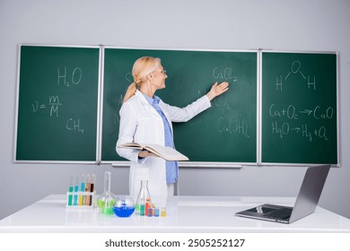 Photo of smart intelligent senior woman school teacher wear white robe explain lesson isolated on green board background - Powered by Shutterstock