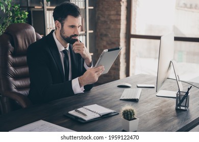 Photo of smart manager sit desk hold tablet finger chin read report wear suit shirt tie in modern office indoors - Shutterstock ID 1959122470