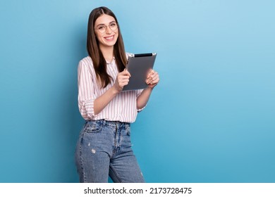 Photo of smart pretty lady dressed pink shirt glasses typing modern gadget empty space isolated blue color background