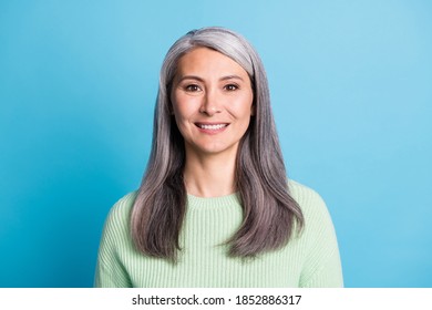 Photo of smiling happy aged nice lady dressed green pullover isolated on blue color background