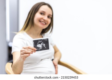 Photo Of Smiling Pregnant Woman With Ultrasound Result.