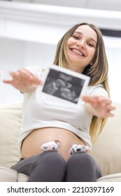 Photo Of Smiling Pregnant Woman With Ultrasound Result.