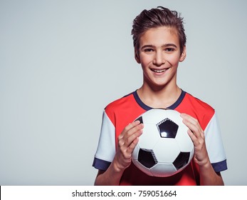 Photo Of Smiling Teen Boy In Sportswear Holding Soccer Ball - Posing At Studio