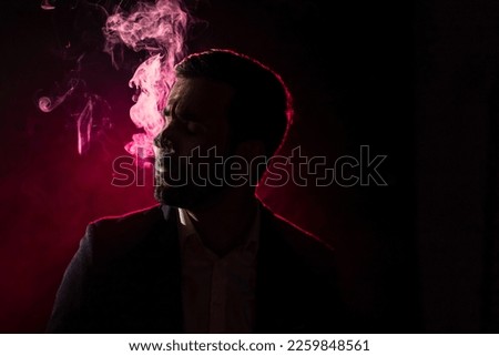 Photo of smoking man on pink background.