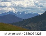 photo of the snow capped seven devils mountains taken from the breaks of the salmon river near Riggins ID with a background of storm clouds