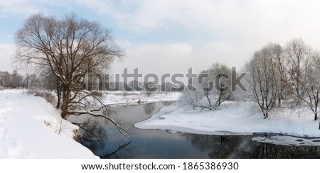 Photo the snow-covered river did not freeze in winter.The river flows in winter. Snow on the branches of trees. Reflection of snow in the river. Huge snowdrifts lie on the Bank of the stream.