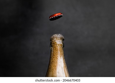 Photo Of  Soda Drink In Glass Bottle Open With Foam And Water Drop On Dark Background.