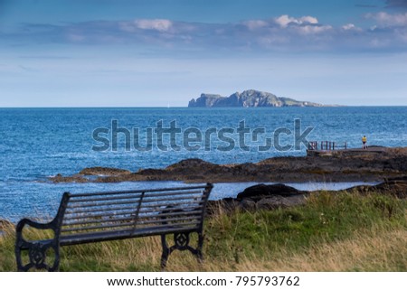 A Photo of some people swimming at the Low Rock in Malahide with Irelands Eye in the Background.