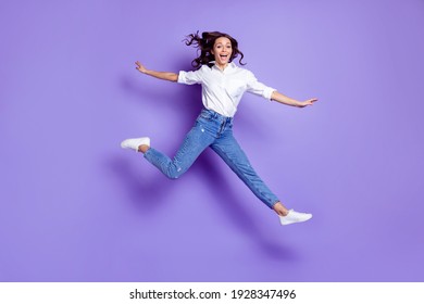 Photo Of Sportive Active Lady Jump Open Mouth Wear White Shirt Jeans Shoes Isolated Violet Color Background