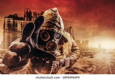 Photo of a stalker in jacket and gloves in damaged gas mask with filter reaching out his hand to camera on destructed apocalyptic wasteland city background.