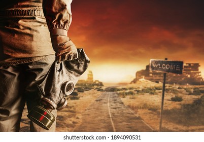 Photo of a stalker in jacket and gloves holding gas mask with filter on destructed apocalyptic wasteland city background.
