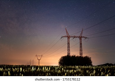 Photo of the starry sky with a view of the field and power lines.