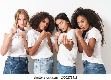 Photo of a strong young women multiracial friends posing isolated over white wall background standing in boxing pose.