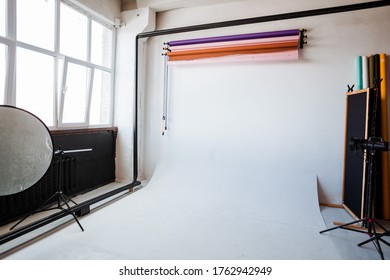 photo Studio interior, white cyclorama, colored backgrounds, lighting device on a tripod