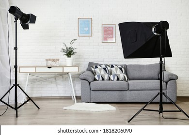 Photo Studio With Professional Equipment And Home Interior On Brick Wall Background