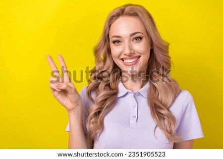 Photo of stunning positive person beaming smile hand fingers demonstrate v-sign isolated on yellow color background