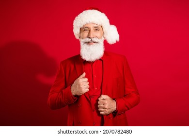 Photo of successful business man santa claus toothy beaming smile posing wear x-mas hat suit on red color background - Powered by Shutterstock