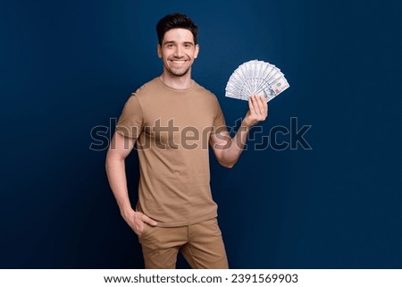 Photo of successful nice man showing banknotes casino lottery jackpot isolated on dark blue color background