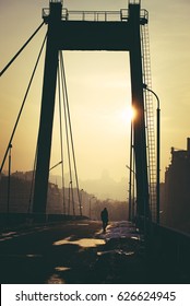 Photo In Summer Blockbuster Look Of City Landscape With A Lonely Man Walking Through An Empty Bridge.